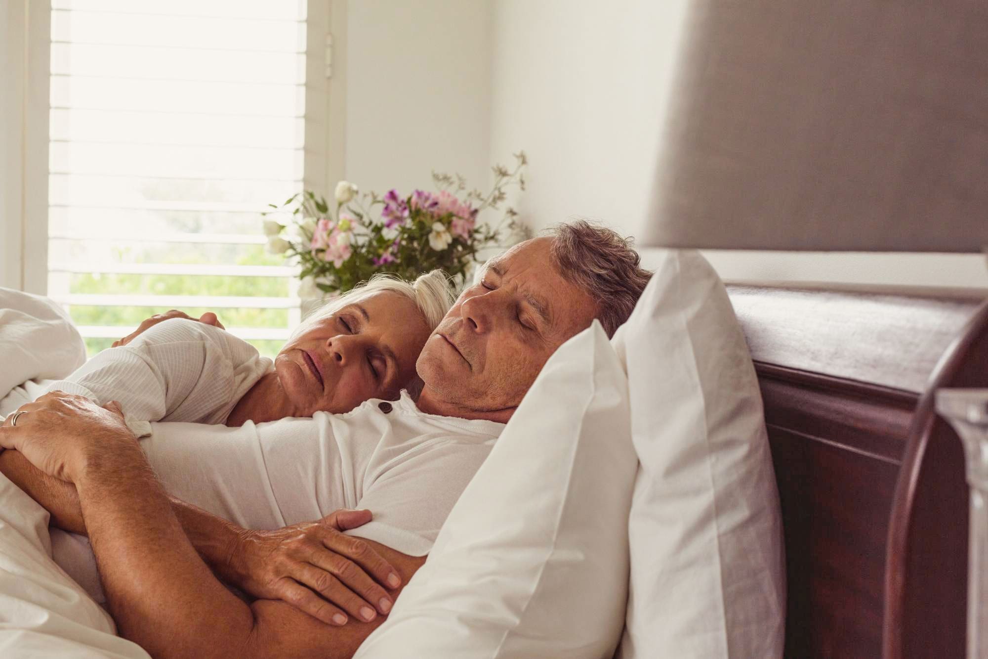 active-senior-couple-sleeping-together-bed-bedroom-comfortable-home